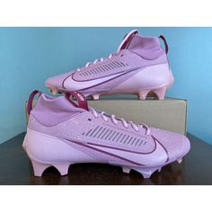 a pair of purple nike soccer cleats sitting on top of a box