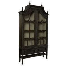 an old fashioned china cabinet with glass doors and carvings on the front, in dark wood