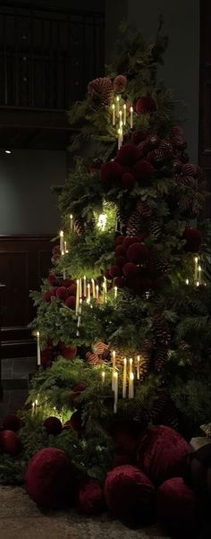 a christmas tree with lit candles in it