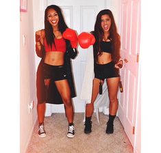 two young women standing next to each other holding red boxing gloves and punching mitts