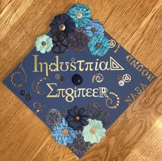 a blue graduation cap that says, indusustriala engineer on it with flowers and beads