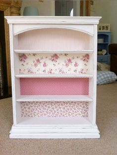 a white book shelf with pink flowers on it