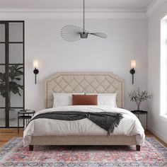 a bedroom with a bed, rug and two lamps hanging from the ceiling above it