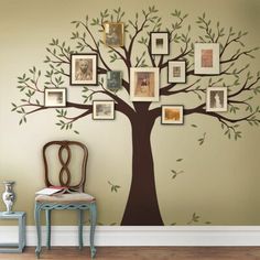 a tree with many pictures on it and a chair next to it in front of the wall