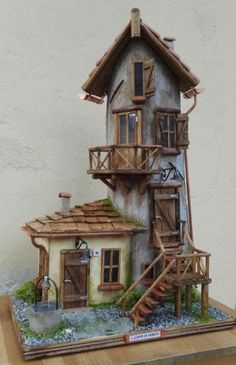 a doll house made out of wood with stairs leading up to the roof and windows