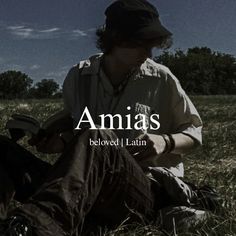 a man sitting in the grass with his legs crossed and reading a book, which reads amis beloved latin