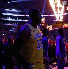 a man standing in front of a crowd at a basketball game wearing a lakers jersey