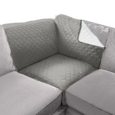 a gray couch with two pillows on it's back and the seat folded down