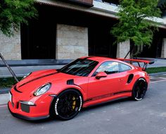 a red sports car parked in front of a building