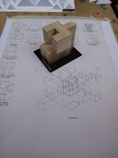 a wooden object sitting on top of a piece of paper with drawings and shapes around it