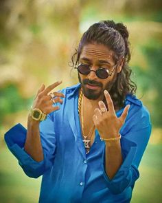 a man with long hair and sunglasses making the peace sign