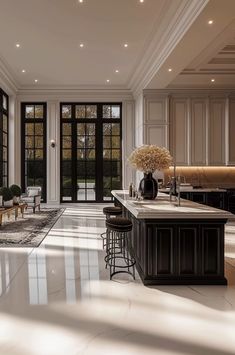 an elegant kitchen with marble counter tops and white walls, along with large glass doors