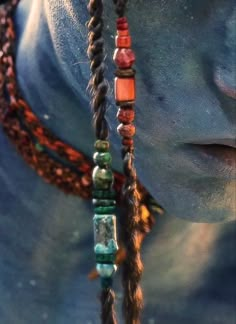 the head and neck of a statue with beads on it