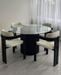 a glass table with four chairs around it