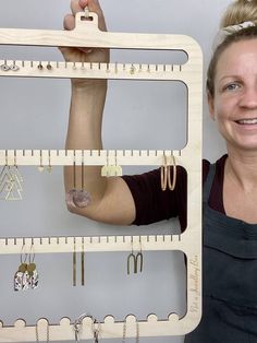 a woman standing next to a wall mounted jewelry organizer