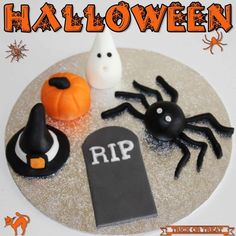 there is a cake decorated to look like a spider and other halloween decorations on the plate