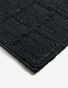 the textured black area rug is laid out