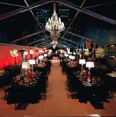 an indoor dining area with chandeliers and tables set up for formal function at night