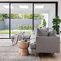 a living room filled with furniture and a large glass door leading to a backyard area