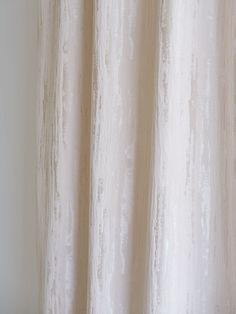 a white curtain hanging on the side of a window