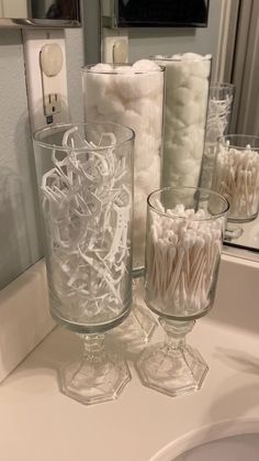 there are many rolls of toilet paper on the bathroom counter next to the glass vase