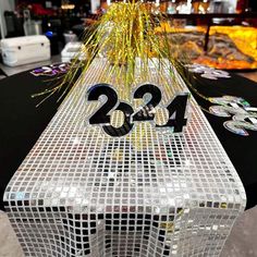 the number twenty twenty four sits on top of a table with confetti and streamers