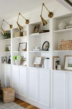 a living room filled with lots of white bookshelves covered in pictures and decor