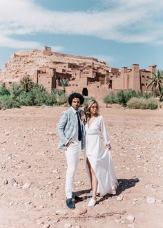 a man and woman are standing in the desert