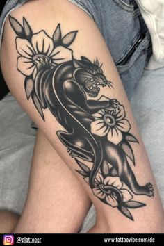 a woman's thigh with a black and white tattoo design on her leg,