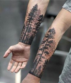 a man with a forest tattoo on his arm and wrist is holding the hand of another person