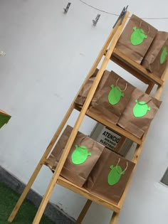 several bags with green paper on them are sitting on a wooden steplader in front of a building