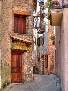 an alleyway with stone buildings and wooden doors