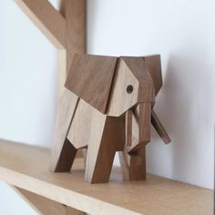 an elephant made out of wood sitting on top of a shelf