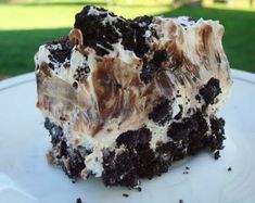 a close up of a piece of cake on a plate with grass in the background