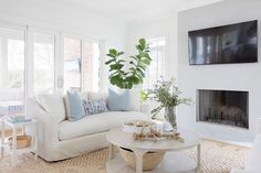 a living room filled with furniture and a fire place in front of a tv mounted on the wall