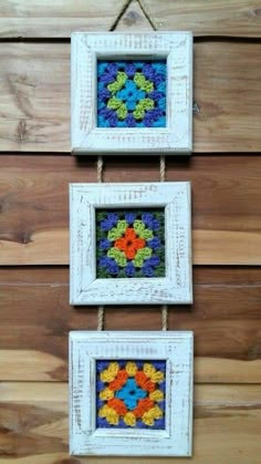 two frames are hanging on the wall with string and yarn in them, one is decorated with colorful flowers