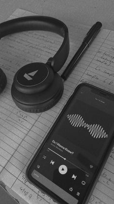 an mp3 player and headphones sitting on top of a piece of paper next to a pen