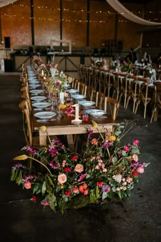 a long table with flowers and candles on it is set up for a wedding reception