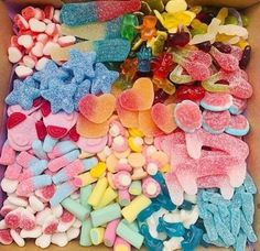 a box filled with lots of different colored candies and marshmallows next to each other