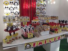 a table topped with lots of mickey mouse themed desserts and decorations on top of it