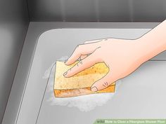 a person cleaning a counter top with a sponge on it's side and a hand holding a rag over the edge