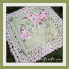 a crocheted square with pink flowers on it