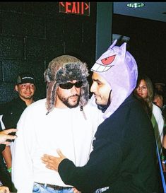 two men in costumes hugging each other at a party