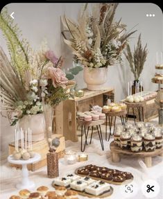 an assortment of desserts and pastries on a table with flowers in vases