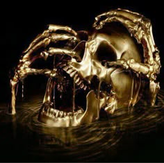 a gold skull with its mouth open and hands on it's face, in the water