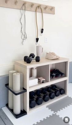 a shelf with various items on it in a room that is white and has grey flooring