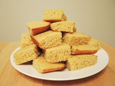 a white plate topped with cut up cornbreads on top of a wooden table