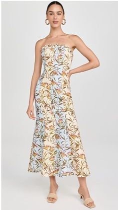 a woman is wearing a dress with flowers on it