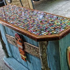 an old wooden box with many different colored buttons on it's lid and sides