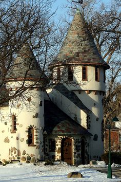 an old castle like building with a clock on it's side in the snow